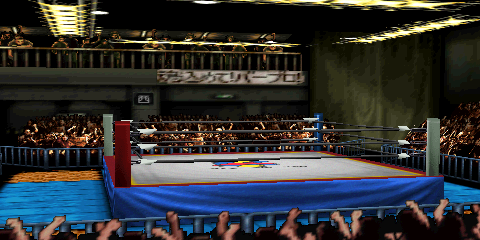 Screenshot of AKI Hall, equally focused
on the ring area, as well as one of the balconies. The balcony area features a
few fans, guardrails, and a hanging cloth sign with Japanese text. The overhead
ring lighting setup is visible in this screenshot. The ring has a mat design
featuring the AKI Corporation logo. Most of the canvas is gray, but there is a border
section containing a yellow stripe and larger red area. The ring skirt is blue,
as are the outside mats. The outside corners (only one of which is clearly visible
in this screenshot) are parquet wood floor.